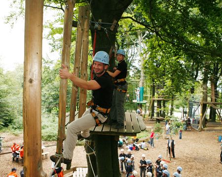Beveiligde klimmer met helm in het klimpark in Detmold