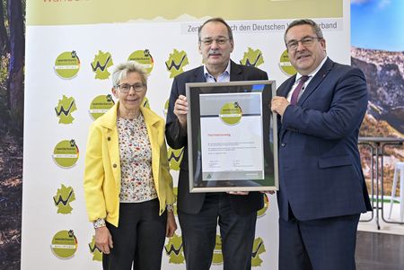 Dr. Axel Lehmann übernimmt auf der Messe Caravan Salon in Düsseldorf 2025 das Zertifikat "Qualitätsweg Wanderbares Deutschland" für das Hermannsweg